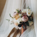 gorgeous wedding shoes, dress and tender bouquet of peonies